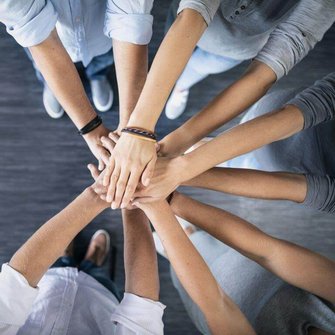 Mehrere Personen legen die Hände aufeinander. Mehrere Personen legen die Hände aufeinander.