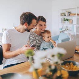 Eine Familie sitzt vor einem Notebook.
